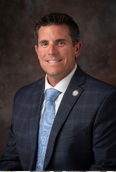 A person in a suit and tieDescription automatically generated with medium confidence